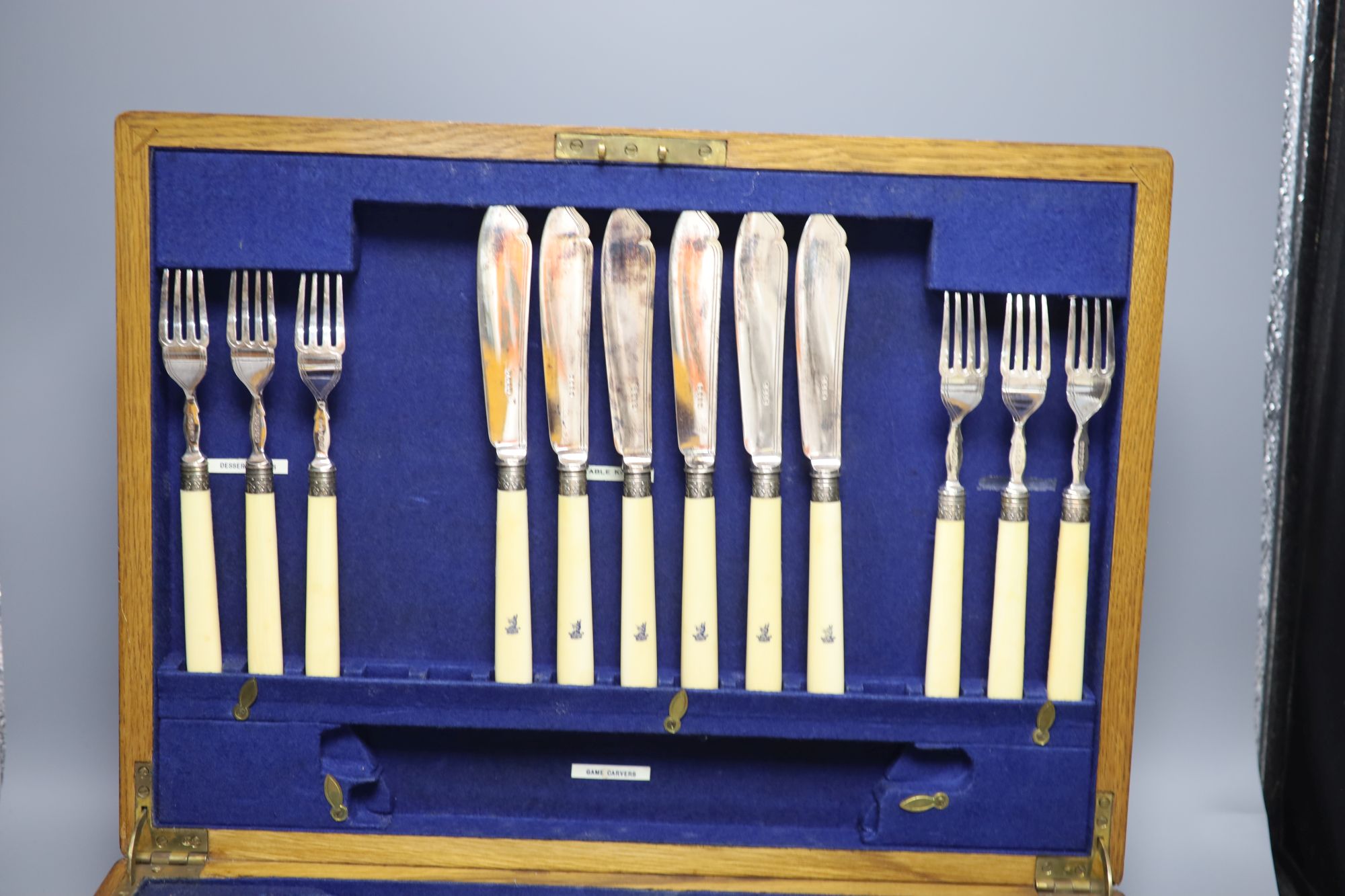 A cased set of silver dessert knives and forks and two other boxes